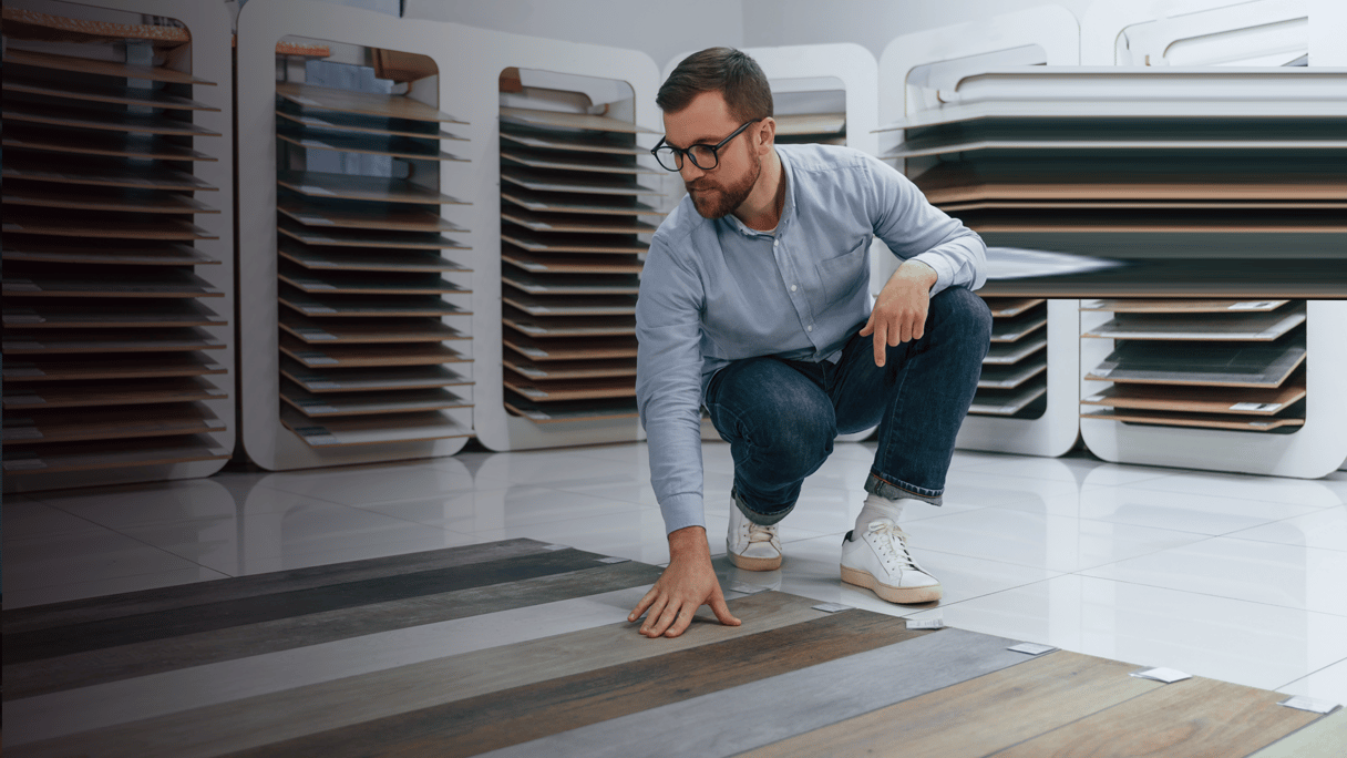 S_Kronos_Sitting and choosing parquet. Man is in the store of goods for the home By mstandret_envato