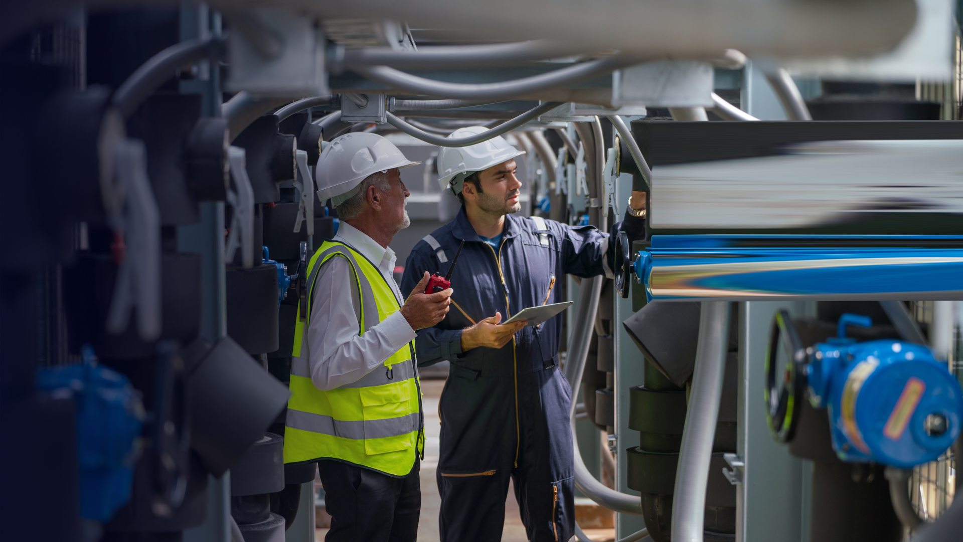 OGE_Two Caucasian engineer as young and senior worker discuss together and stay in channel of pipe By nrradmin_2_envato