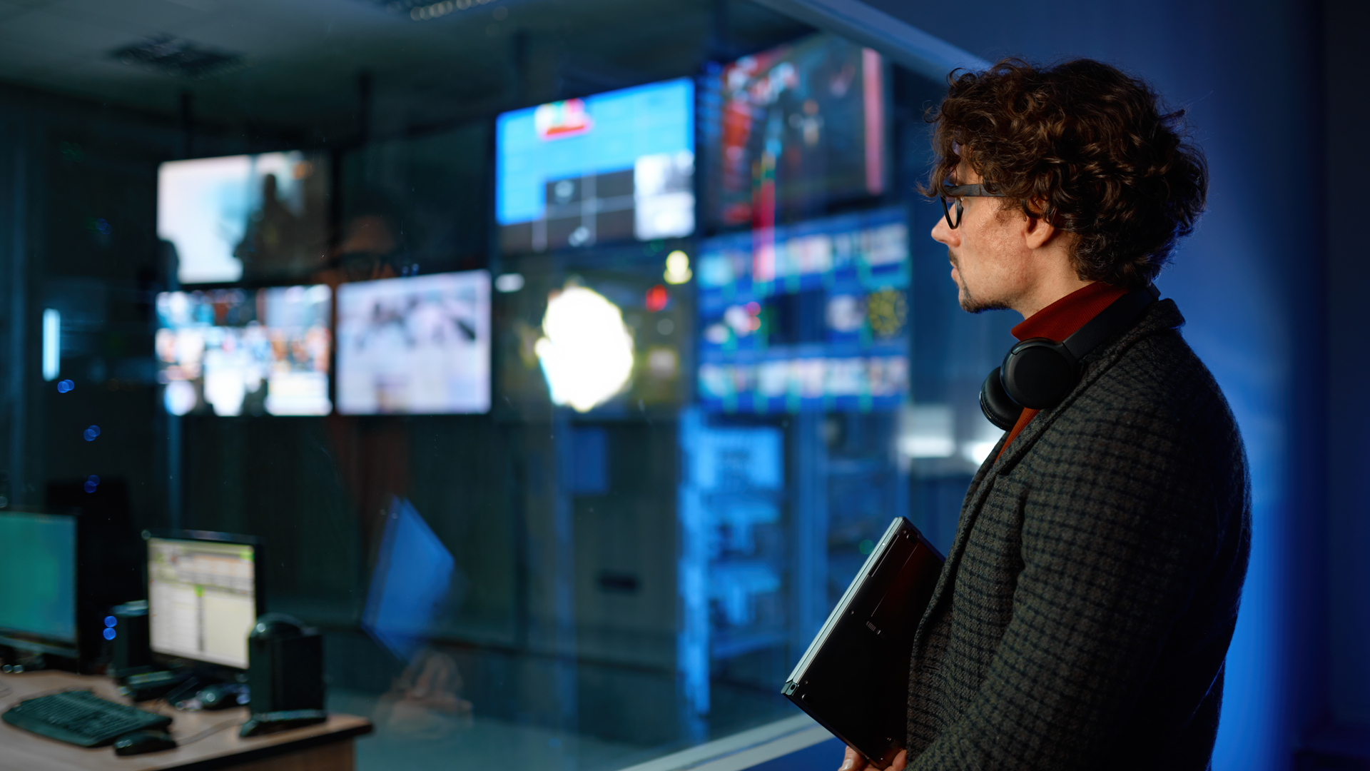 man with glasses looking at screens